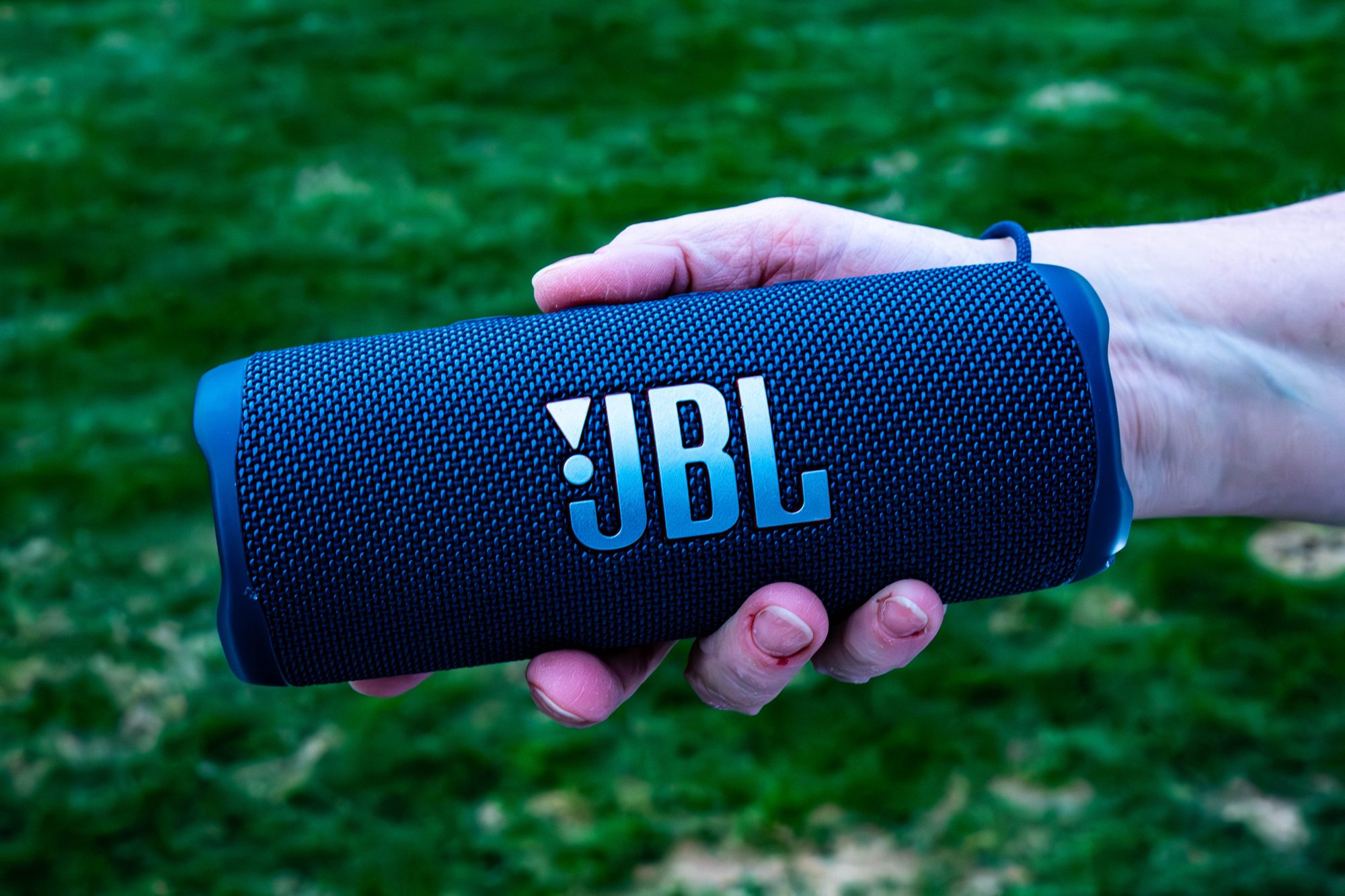 JBL speaker held over grass